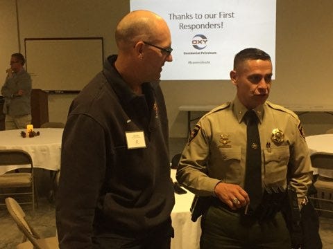 (From left)-Travis Olbert, deputy director of Eddy County Fire Services and Capt. Arsenio Jones of the Eddy County Sheriff's Office talk about emergency services during a dinner Nov. 14, 2018.