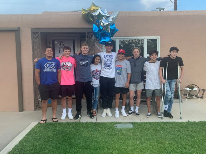 The Carlsbad Cavemen and Cavegirl state wrestling team poses to congratulate Fabian Padilla, center, for winning his state title at 182 pounds. Six of Carlsbad's nine wrestlers won a medal in the tournament.