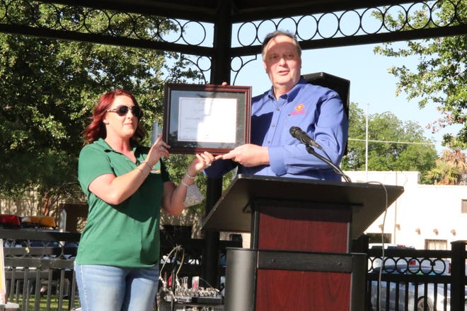Carlsbad MainStreet Director Ashly Key, left, presents Eddy County Manager Allen Davis with a plaque gifting the gazebo on the Eddy County Courthouse lawn.