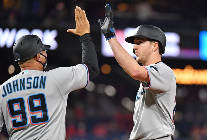 May 19, 2021; Philadelphia, Pennsylvania, USA; Miami Marlins starting pitcher Trevor Rogers (28) gets a high five from first base coach Kevin Johnson (99) after getting a base hit against the Philadelphia Phillies during the seventh inning at Citizens Bank Park. Mandatory Credit: Eric Hartline-USA TODAY Sports