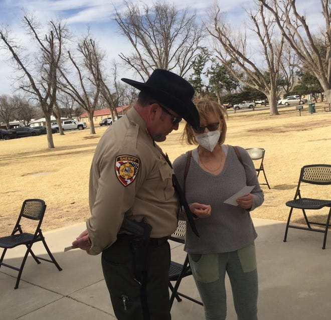 Eddy County Sheriff Mark Cage (left) and Eddy County DWI Program Director Cindy Sharif confer before a memorial service for slain New Mexico State Police officer Darian Jarrott in Carlsbad on Feb. 27, 2021.