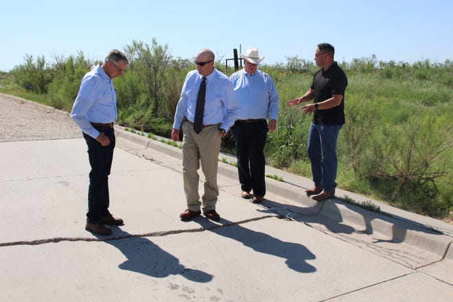 From left: Carlsbad Mayor Dale Janway, Scott Hicks of Smith Engineering, Deputy City Administrator KC Cass and Lt. Gov. Howie Morales look at flood damage along Hidalgo Road on July 9, 2021.