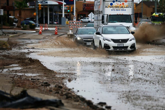 People drive through floodwaters on Mesa Street on Tuesday.