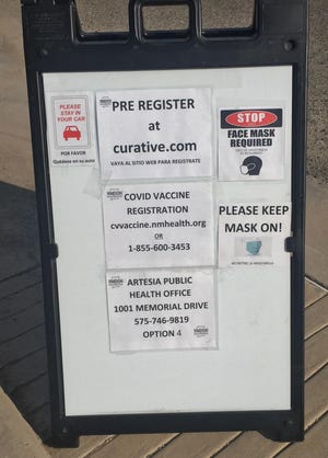 A sign at a drive thru COVID-19 clinic at the Eddy County Public Health Office in Artesia reminds people to register before getting tested or receiving a vaccine.