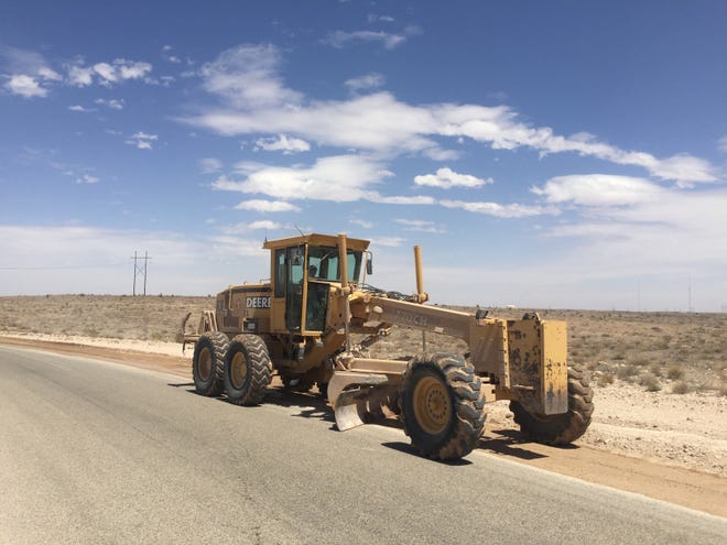 An Eddy County road grader performs dirt work on the side of Illinois Camp Road near Artesia on April 27, 2021.