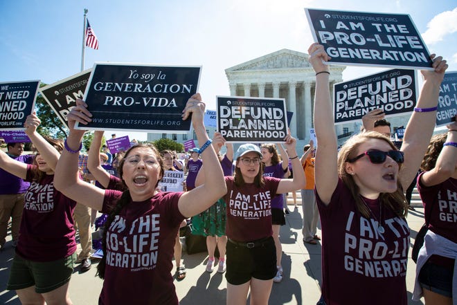 FILE - In this June 25, 2018 file photo, pro-life and anti-abortion advocates demonstrate in front of the Supreme Court in Washington. Republican lawmakers in at least a half dozen GOP-controlled states already are talking about copying a Texas law that bans abortions after a fetal heartbeat is detected. The law was written in a way that was intended to avoid running afoul of federal law by allowing enforcement by private citizens, not government officials.  (AP Photo/J. Scott Applewhite, File) ORG XMIT: NY121